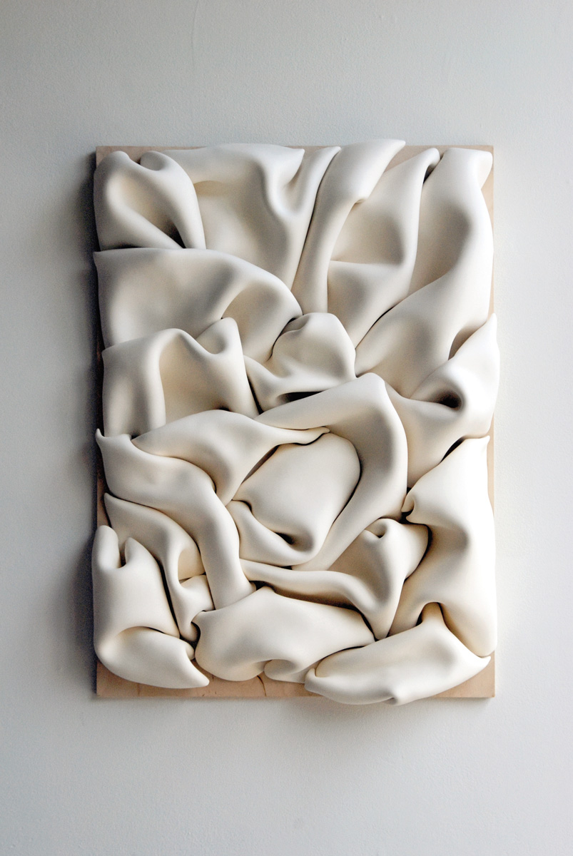 white clay folded into itself on plywood