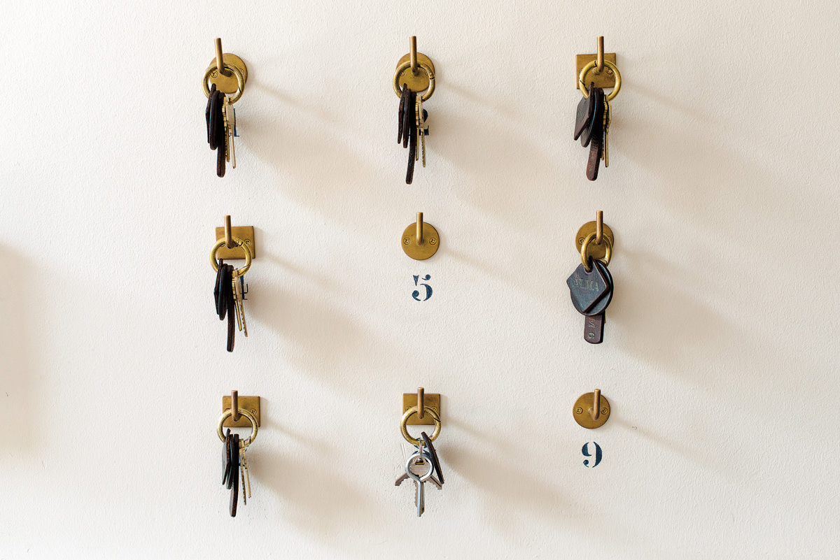 keys hanging on evenly spaced hooks on a wall