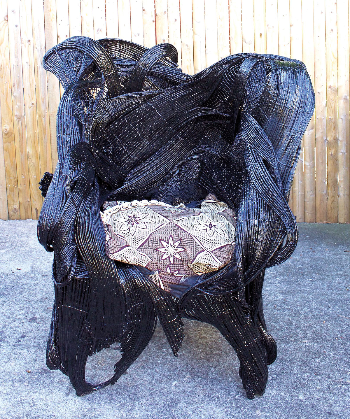 chair made of woven palm spines, metal, wire, hardware cloth, and painted black
