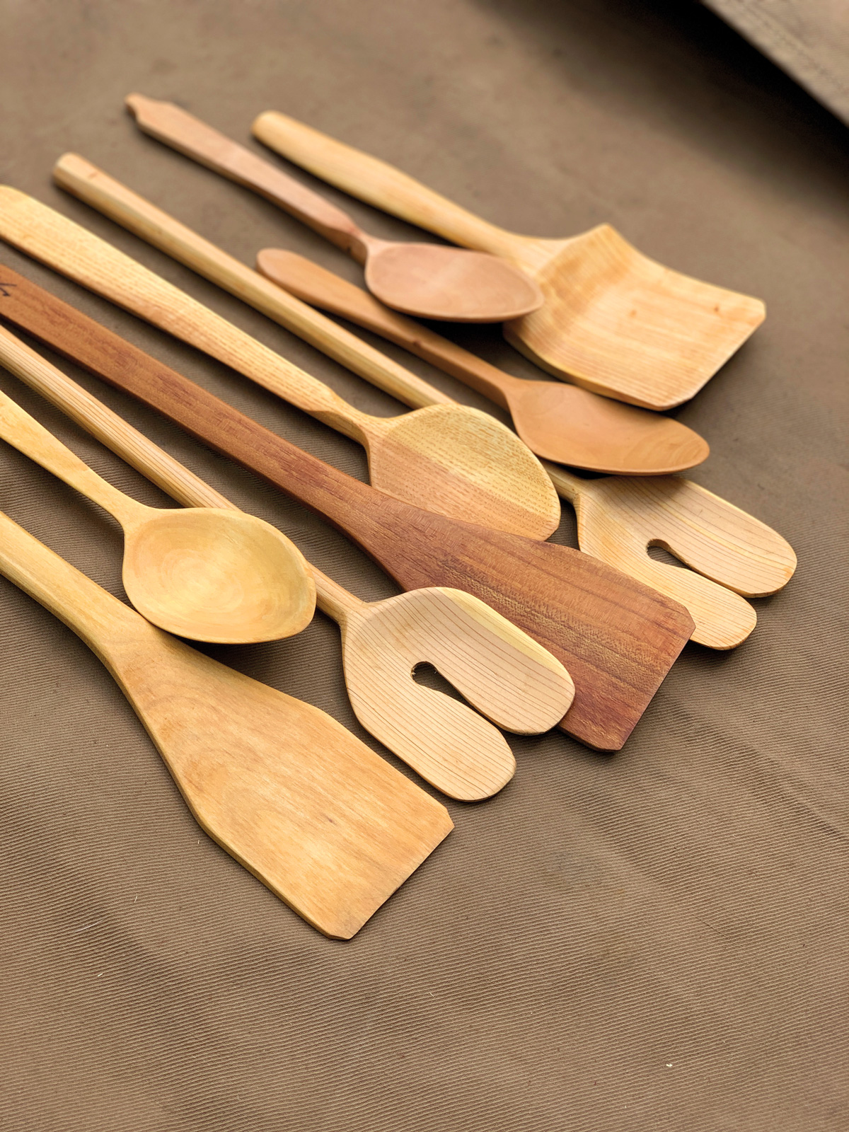 wooden spoons of different sizes and shapes lay on a wooden surface
